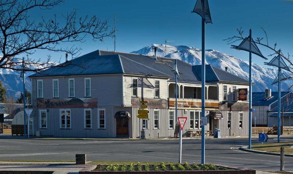 梅斯文The Brown Pub的一座白色的大建筑,背景是一座山