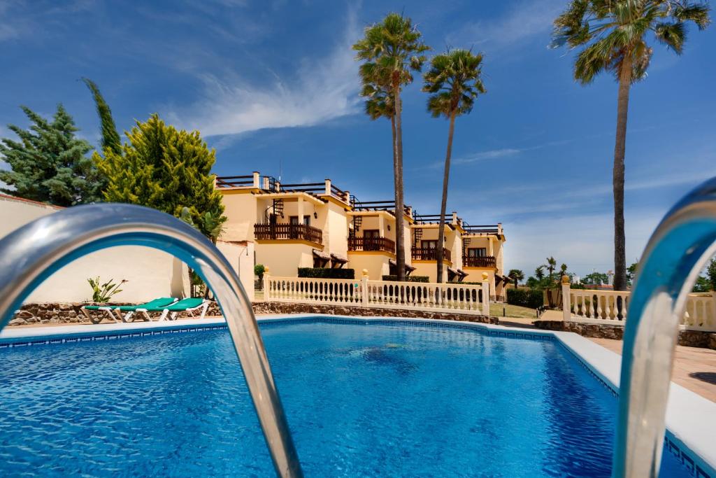 科尼尔-德拉弗龙特拉科尼尔别墅公寓式酒店的棕榈树屋前的游泳池