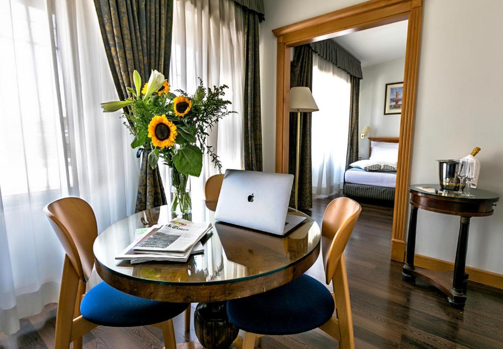 罗马迪普洛麦迪克酒店的配有带笔记本电脑和鲜花的桌子的房间