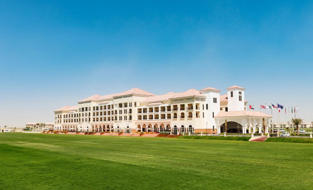 迪拜Al Habtoor Polo Resort的前面有绿地的大建筑