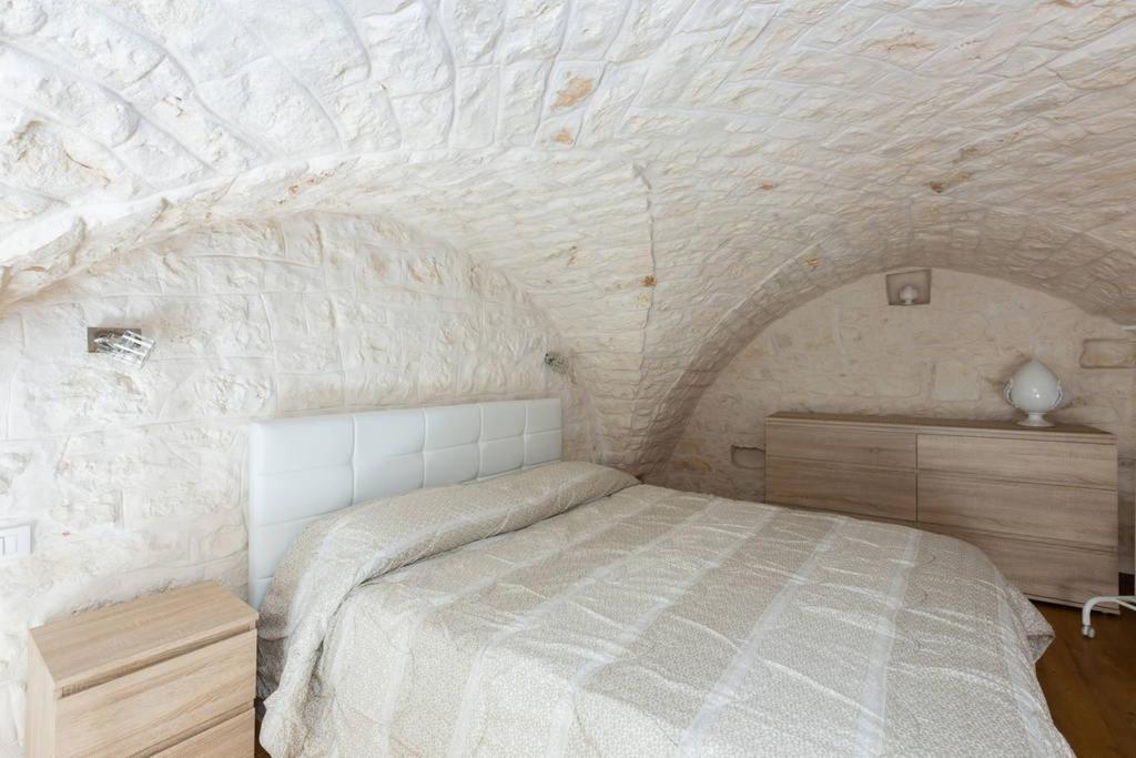 奥斯图尼Dimora Alfonso Pomes的卧室配有一张石墙床