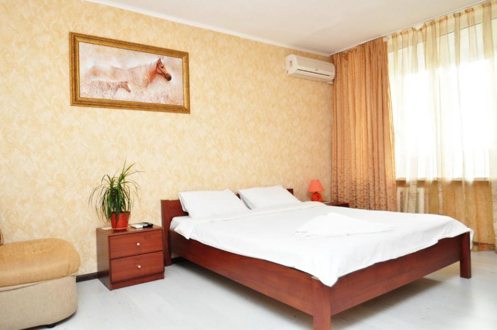 基辅左岸日间公寓的卧室配有床、椅子和窗户。