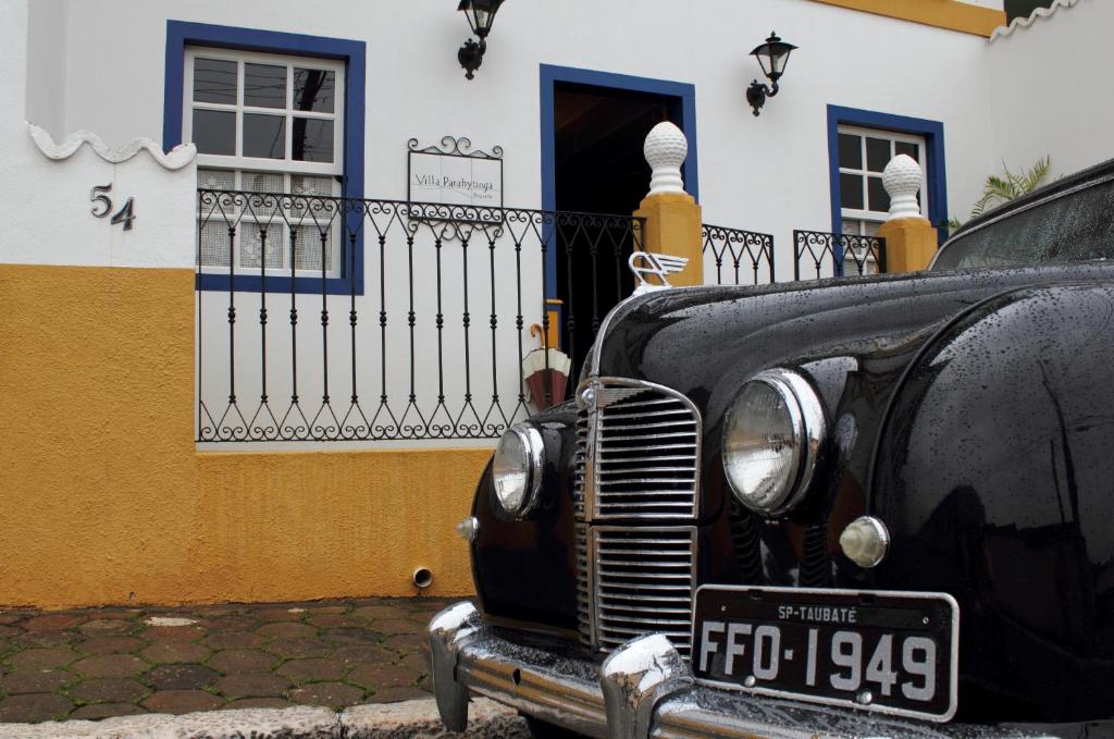 圣路易斯-杜帕赖廷加Pousada Villa Parahytinga的停在大楼前的一辆旧黑车