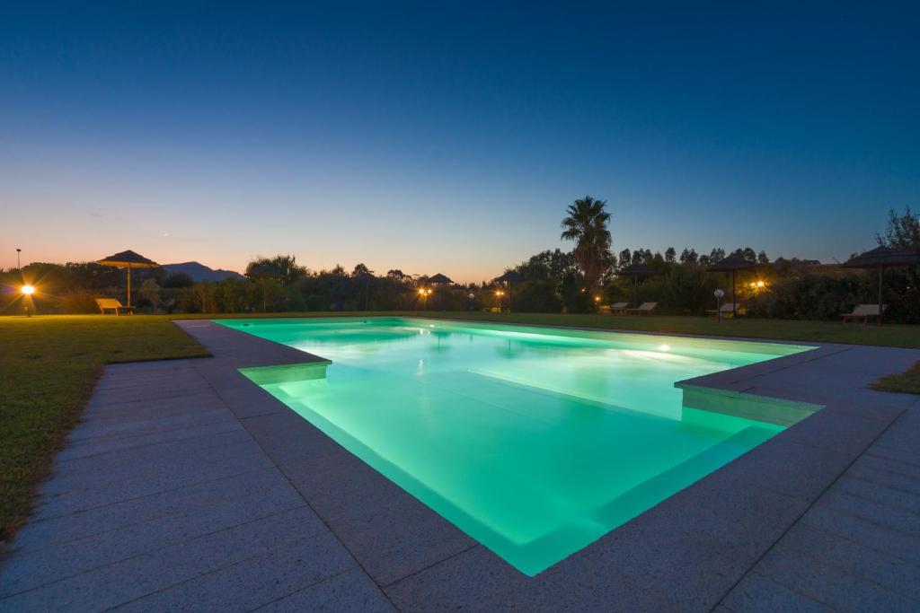 Mores亚纳斯乡村度假酒店的游泳池,晚上有绿色的灯光