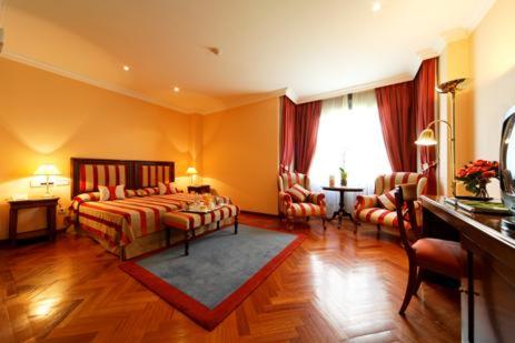 马德里唐皮奥酒店的一间设有床铺和客厅的大房间