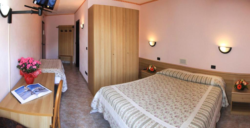 圣文森特勒斯赛松斯酒店的酒店客房设有两张床和一张桌子。