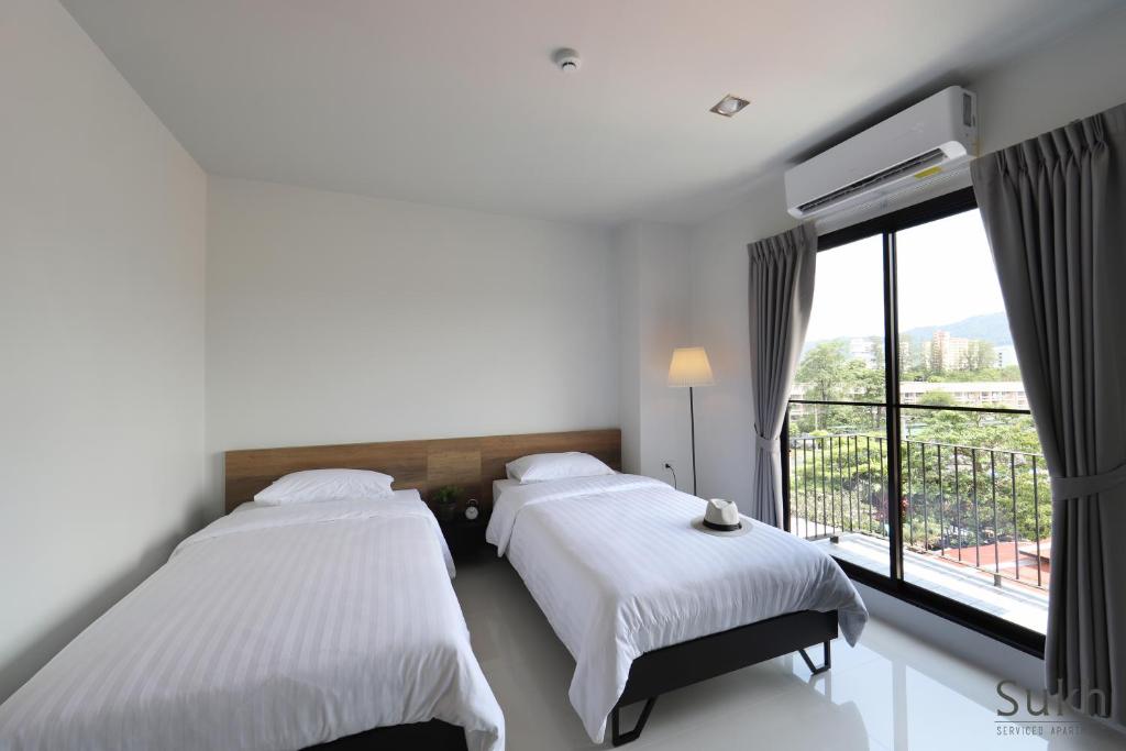 Ban Kohong苏克服务式公寓的带大窗户的客房内的两张床