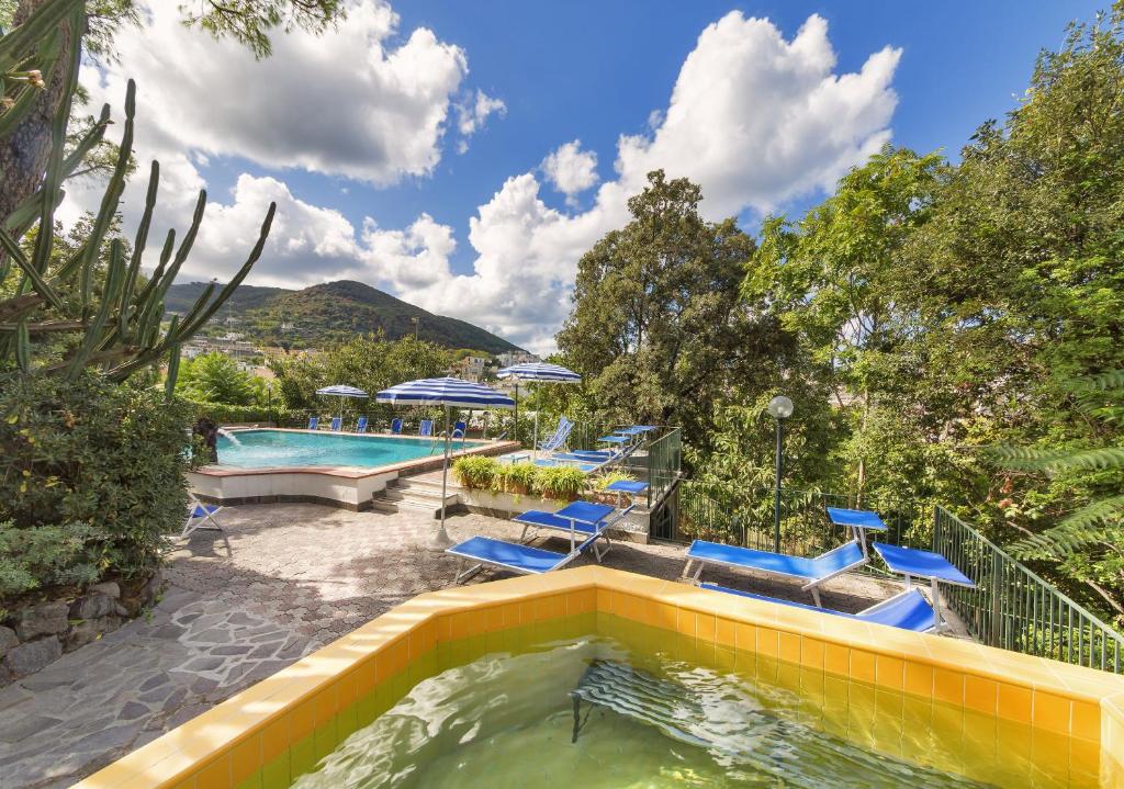 伊斯基亚维多利亚酒店的后院的游泳池,带蓝色椅子