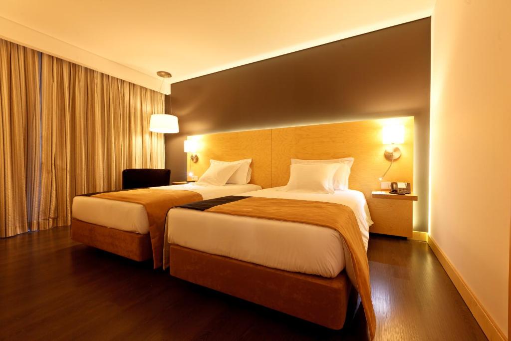 布拉加布拉加市区美居酒店的酒店客房设有两张床和窗户。