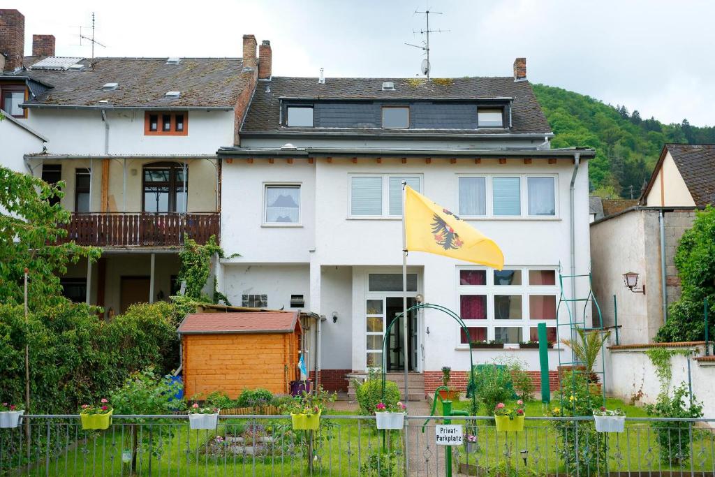 博帕德Niedersburger Eck, wandern, radfahren, genießen, erholen的前面有黄色旗帜的白色房子