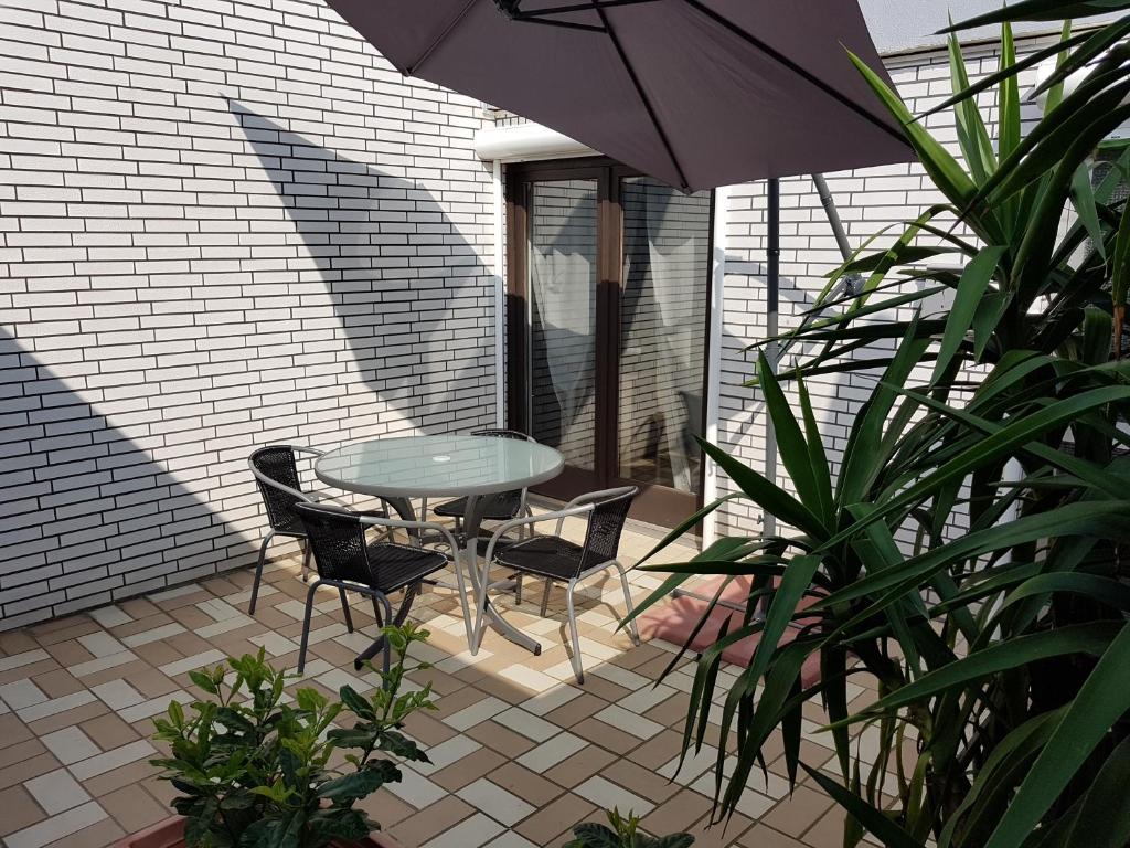 弗里茨拉尔Appartement Stein的庭院配有桌椅和遮阳伞。