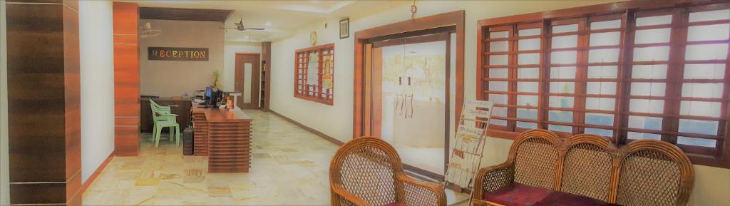 库姆巴科纳姆Hotel Chela的走廊上设有椅子和桌子