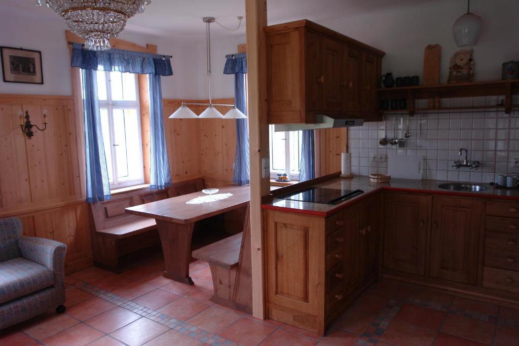 坦瓦尔德Chata Hugo - 3 Retreat Apartments的厨房配有木制橱柜和桌子。