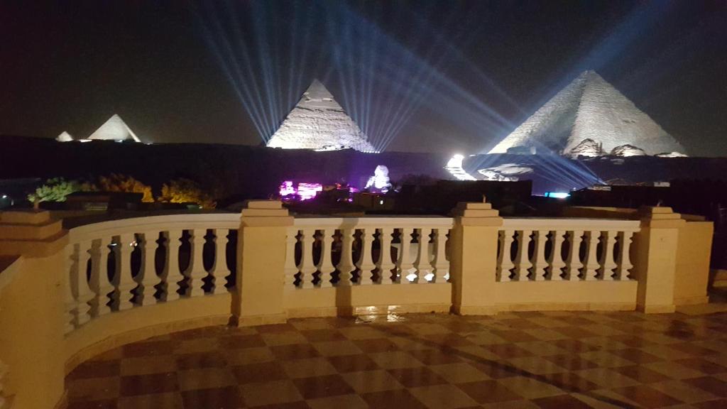 开罗皇家金字塔宾馆 的夜间背景中带有金字塔的白色围栏