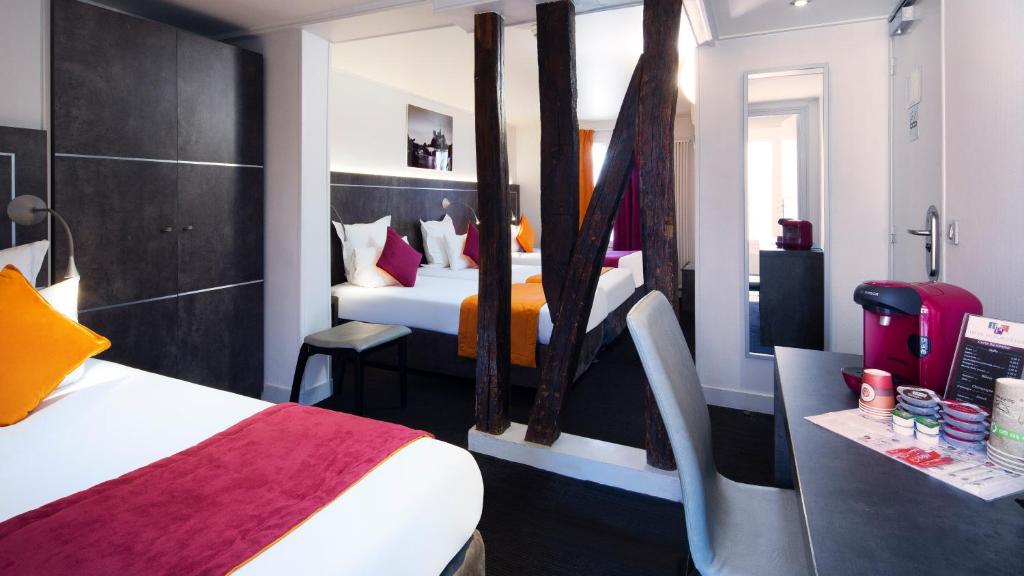 巴黎Hôtel du Plat d'Etain的酒店客房配有两张床和一张书桌