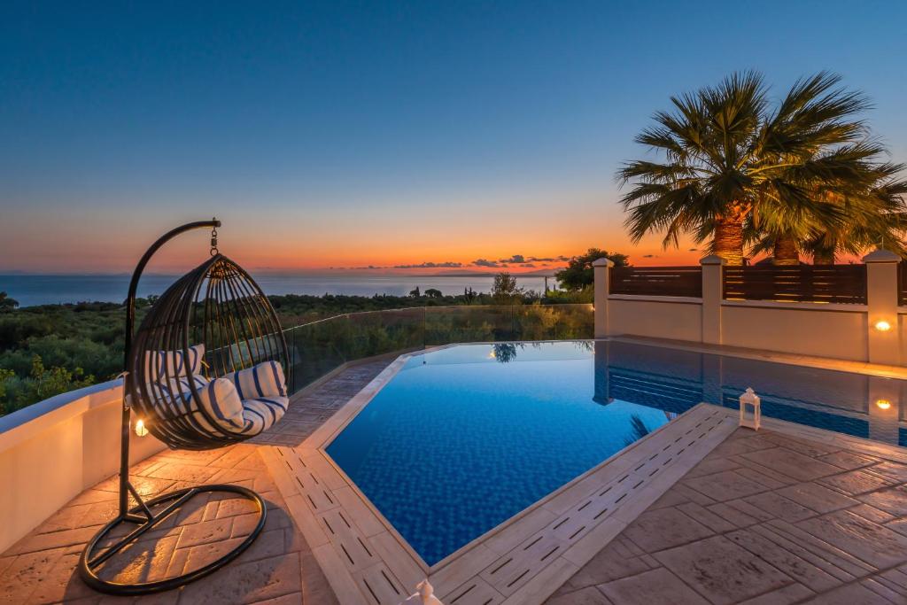 阿克罗蒂Frido Luxury Villa with Jacuzzi的一座带游泳池的房子边的秋千