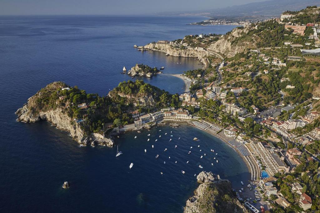 陶尔米纳Villa Sant'Andrea, A Belmond Hotel, Taormina Mare的海港的空中景色,水中有船只