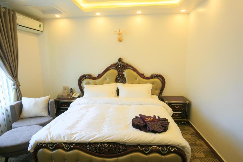 海防范汉酒店的一间卧室配有一张带白色床单的大床