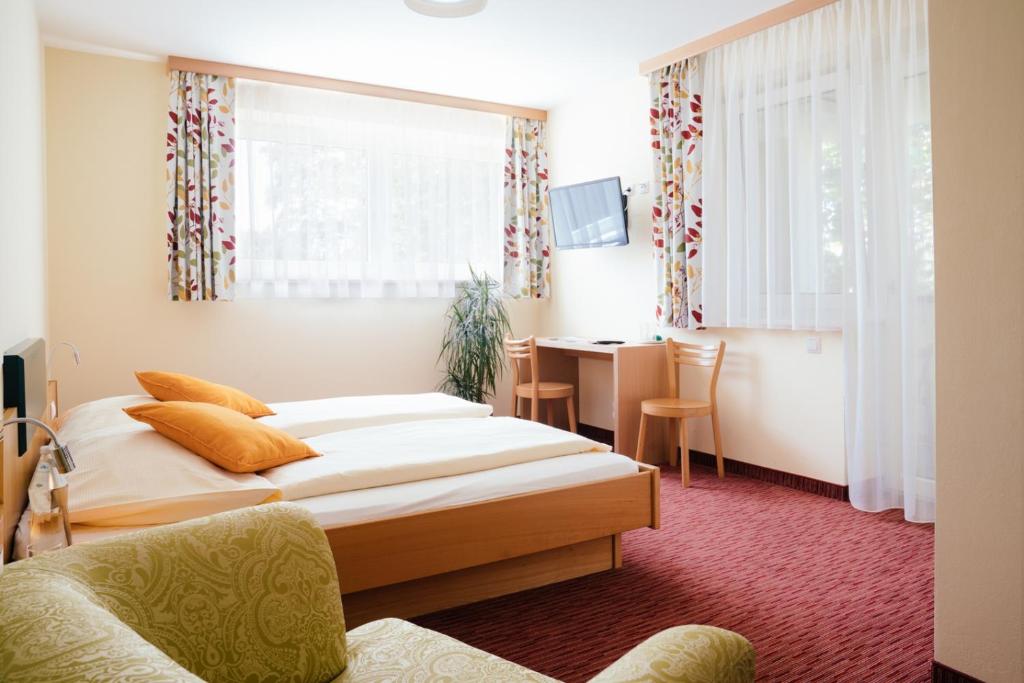 Sankt Martin im Sulmtal格斯玛瑞提旅馆的有两张床和一张书桌的酒店房间