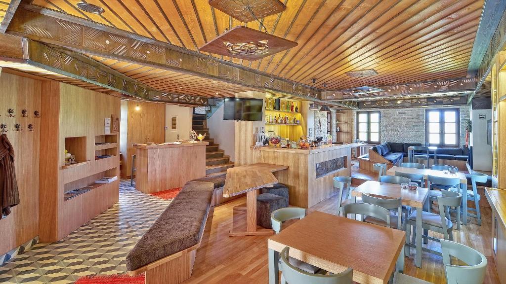 蒂洛弗Dilofo Hotel Luxury Suites的餐厅设有木制天花板和桌椅