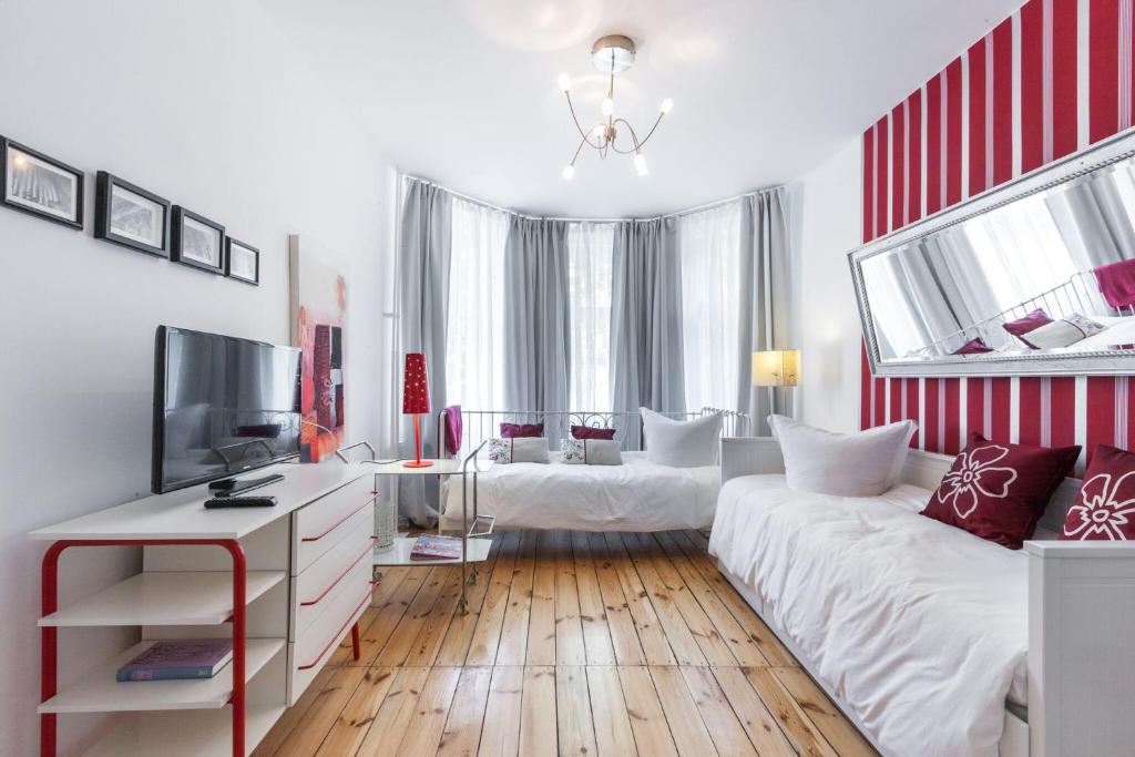 柏林Elegantes 2-Zimmer-Apartment im Kiez von Prenzlauer Berg的一间带两张床和电视的客厅