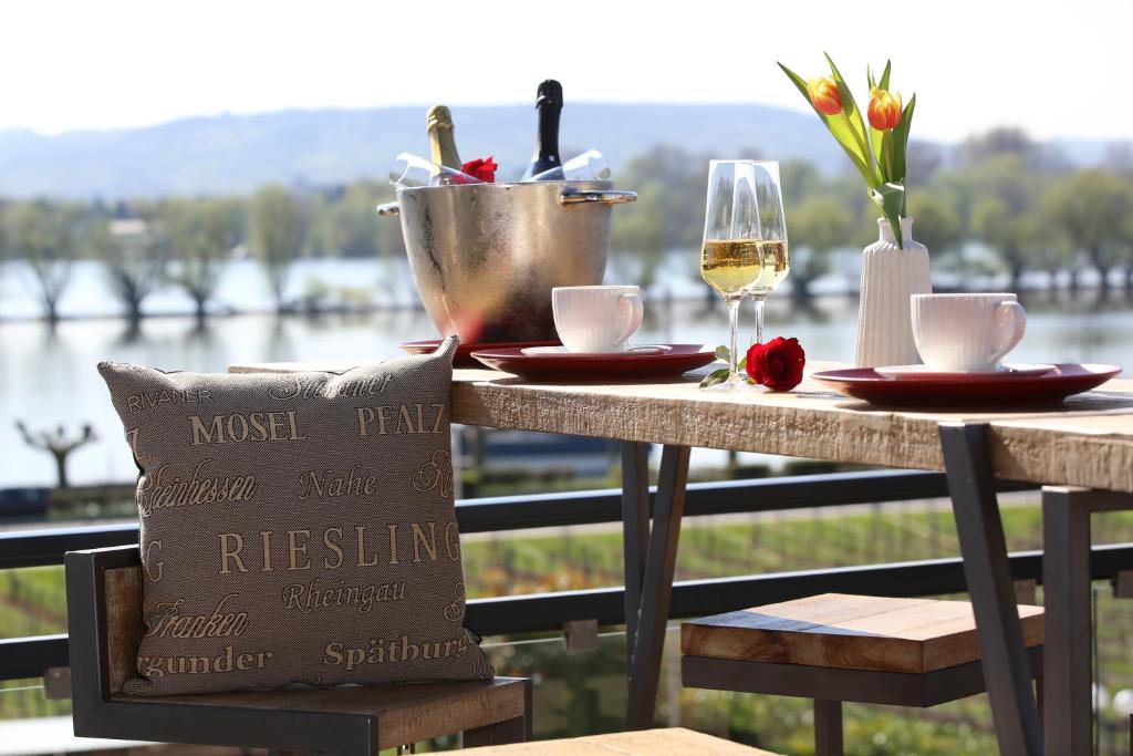 厄斯特里希-温克尔Nägler´s Fine Lounge Hotel的一张桌子,上面放着一杯葡萄酒,桌子享有水景
