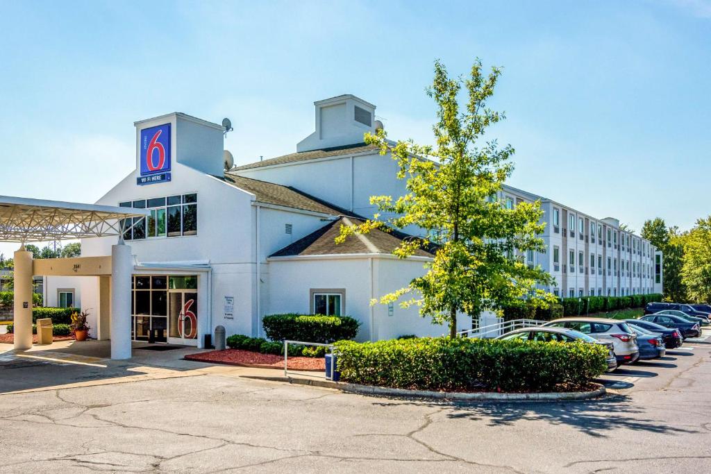 米尔堡Motel 6-Fort Mill, SC - Charlotte的酒店外的停车场停放汽车