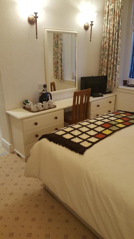 塔尔加斯Tower Hotel的一间卧室配有一张床、一张书桌和一面镜子