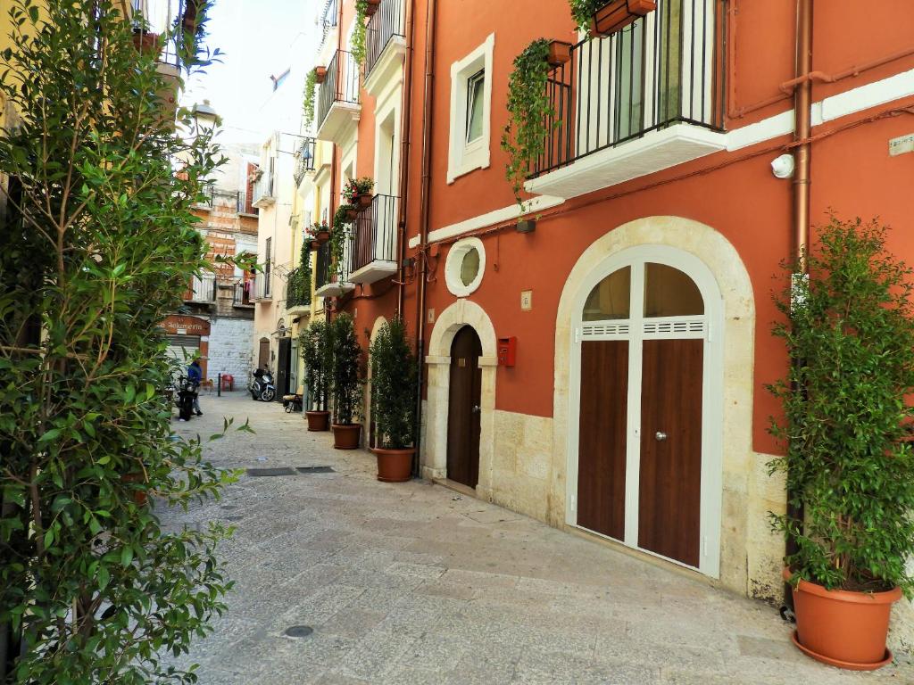巴里Arco Della Neve Guest House的种植着橙色建筑和盆栽植物的小巷