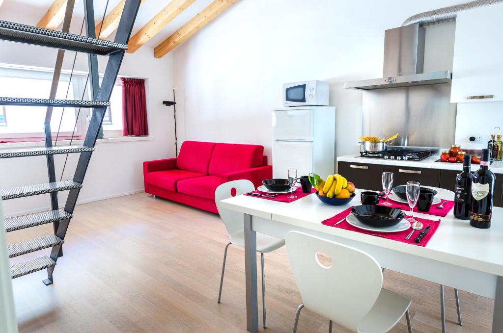 阿科Appartamenti Segantini的一间厨房和一间带红色沙发的客厅