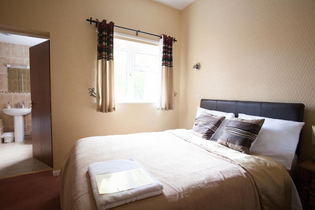 伍尔弗汉普顿男爵庭院酒店的一间卧室设有一张大床和窗户