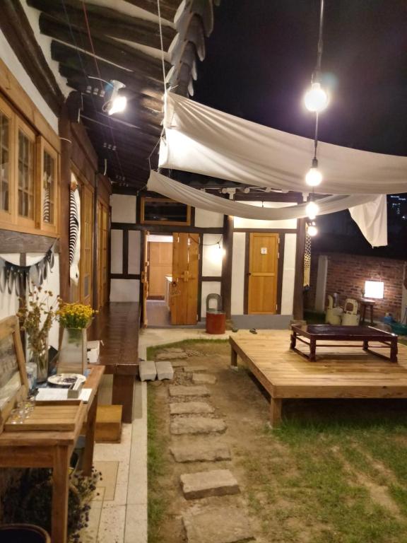 木浦市百年韩屋旅馆的一个带木桌和白色帐篷的庭院