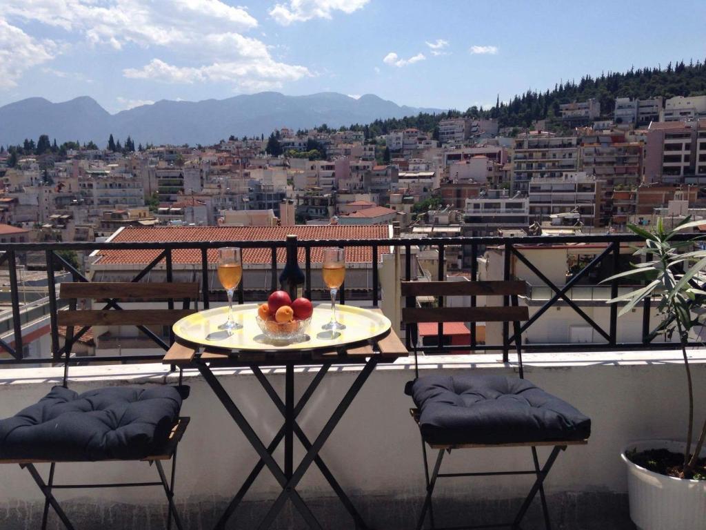 拉米亚Cozy Loft - Best view of the city的阳台上的桌子和两杯葡萄酒