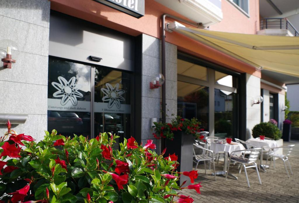 Arnegg圣加仑加尼酒店的大楼前有红花的餐厅
