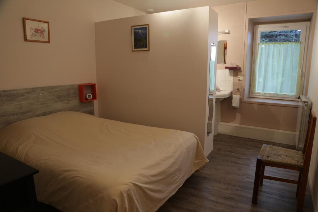 Les Sauvages德拉洛赫酒店及餐厅的一间卧室配有床、水槽和窗户