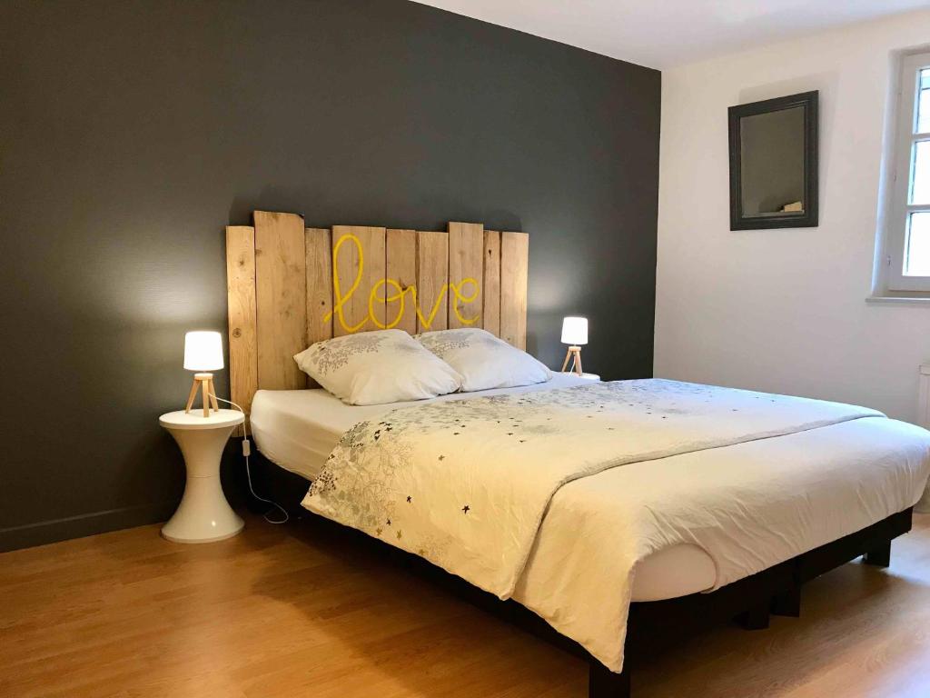 科尔马MyAlsace的一间卧室配有一张大床和木制床头板