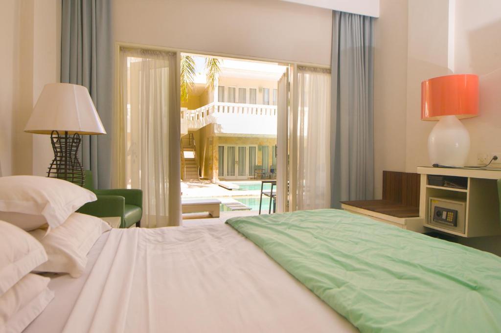勒吉安巴厘岛庭院公寓及酒店的一间卧室配有一张床,另一间卧室配有庭院