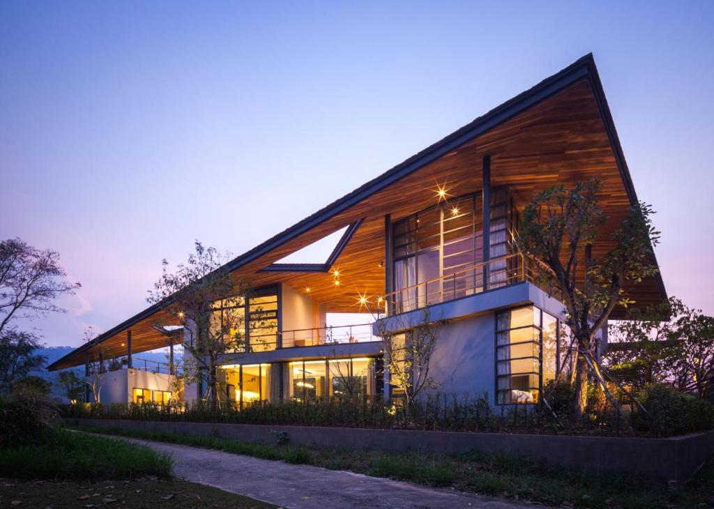 慕斯Gliding Villa in Khao Yai的一座在晚上拥有木饰的大房子