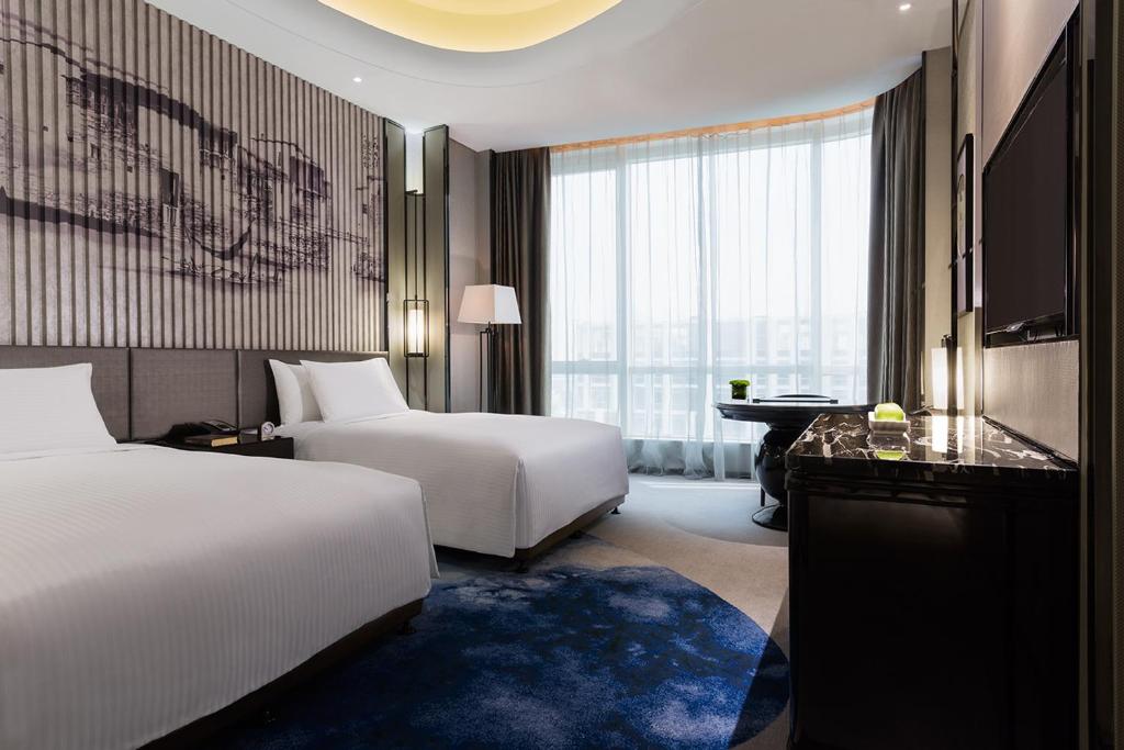 芜湖芜湖富力万达嘉华酒店的酒店客房配有两张床和一张书桌
