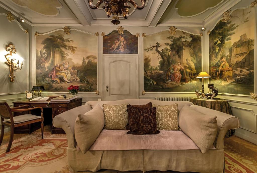 布鲁日玉龙住宿加早餐酒店的客厅配有沙发,墙上挂有绘画作品