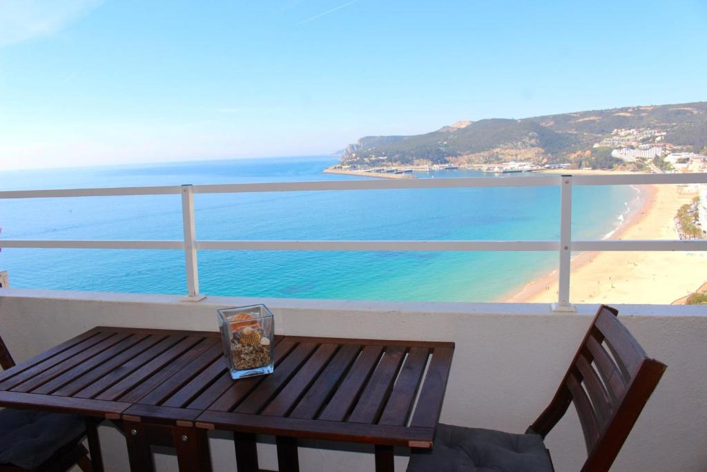 塞辛布拉Akisol Sesimbra Beach的一张木凳,位于俯瞰海滩的阳台