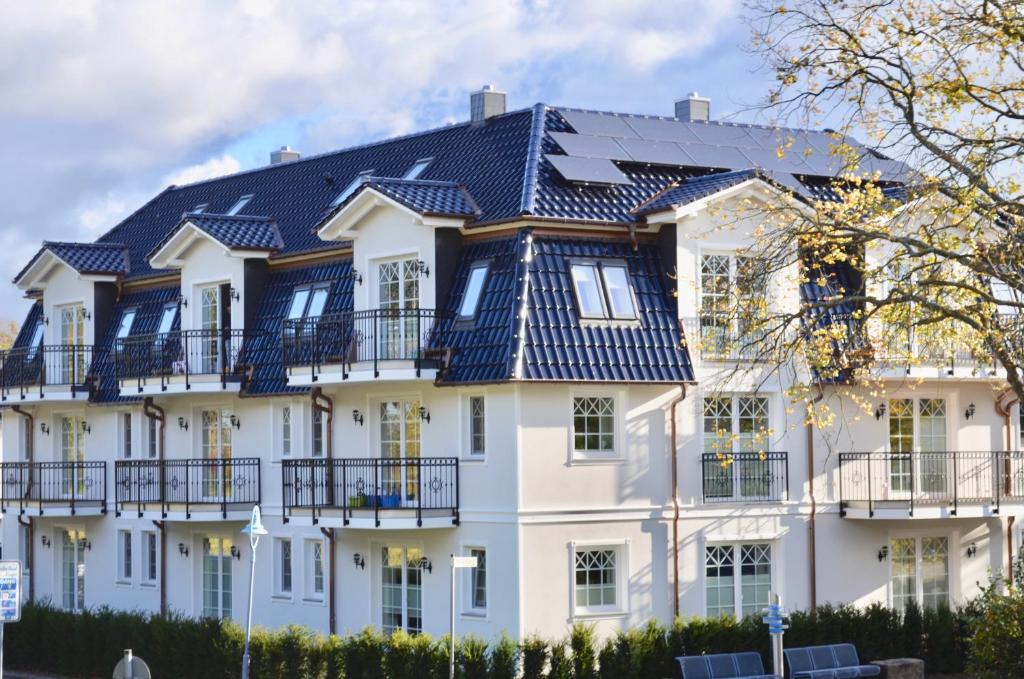 青斯特Villa Strandblick 4的黑色屋顶的大型白色房屋