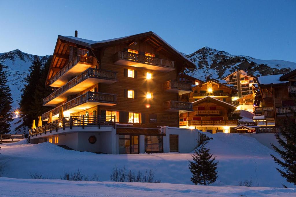 雷克罗塞Mountain Lodge, Les Crosets的一座大建筑物,在晚上下雪