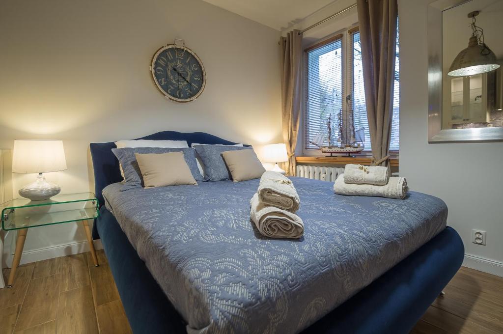 索波特Blue Boat Apartment Sopot的一间卧室配有蓝色的床和毛巾