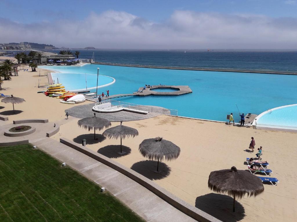 阿尔加罗沃San Alfonso del Mar Departamentos的享有带遮阳伞的游泳池和大海的顶部景致