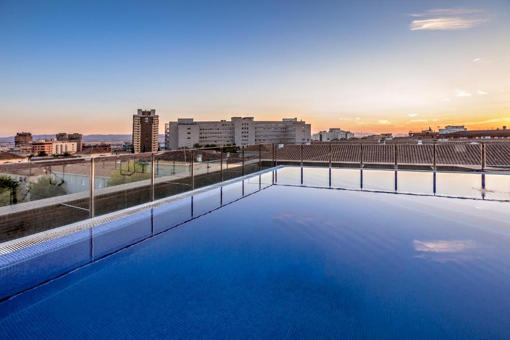 格拉纳达Hotel Granada by Pierre & Vacances的一座城市天际线建筑的顶部游泳池