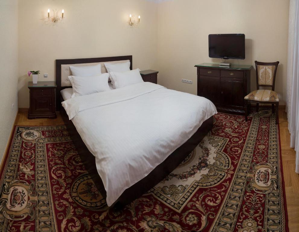 基希讷乌Villa Romantica on Vlaicu-Pircalab的卧室配有一张白色大床和地毯。
