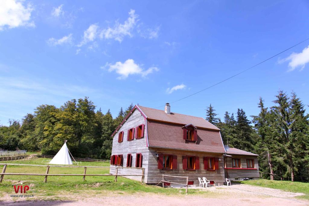 贝尔蒙特Les gîtes de la Serva的一座带红色窗户和白色帐篷的旧谷仓