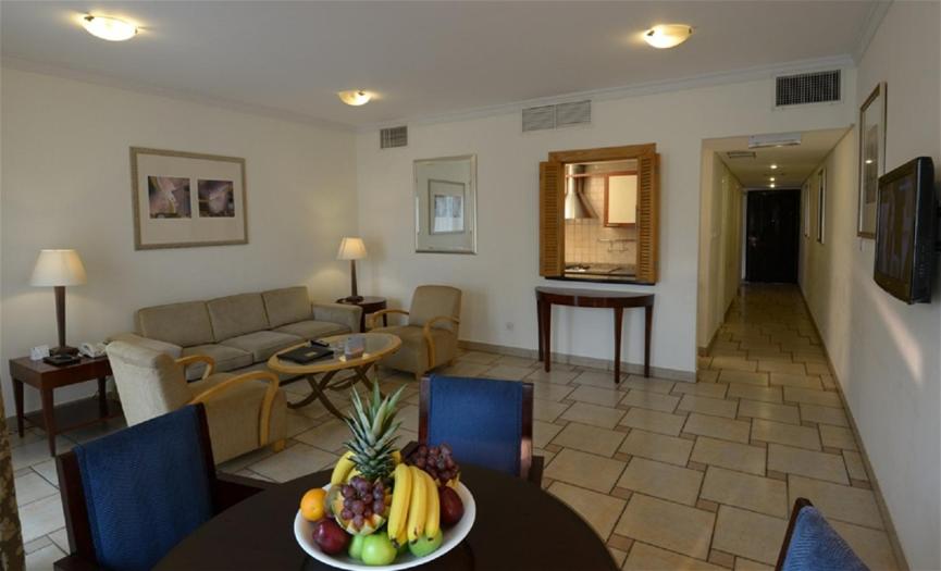 Al Qulay‘ahSeashell Julai'a Hotel & Resort Family resort的客厅里设有一张桌子,上面放着一碗水果
