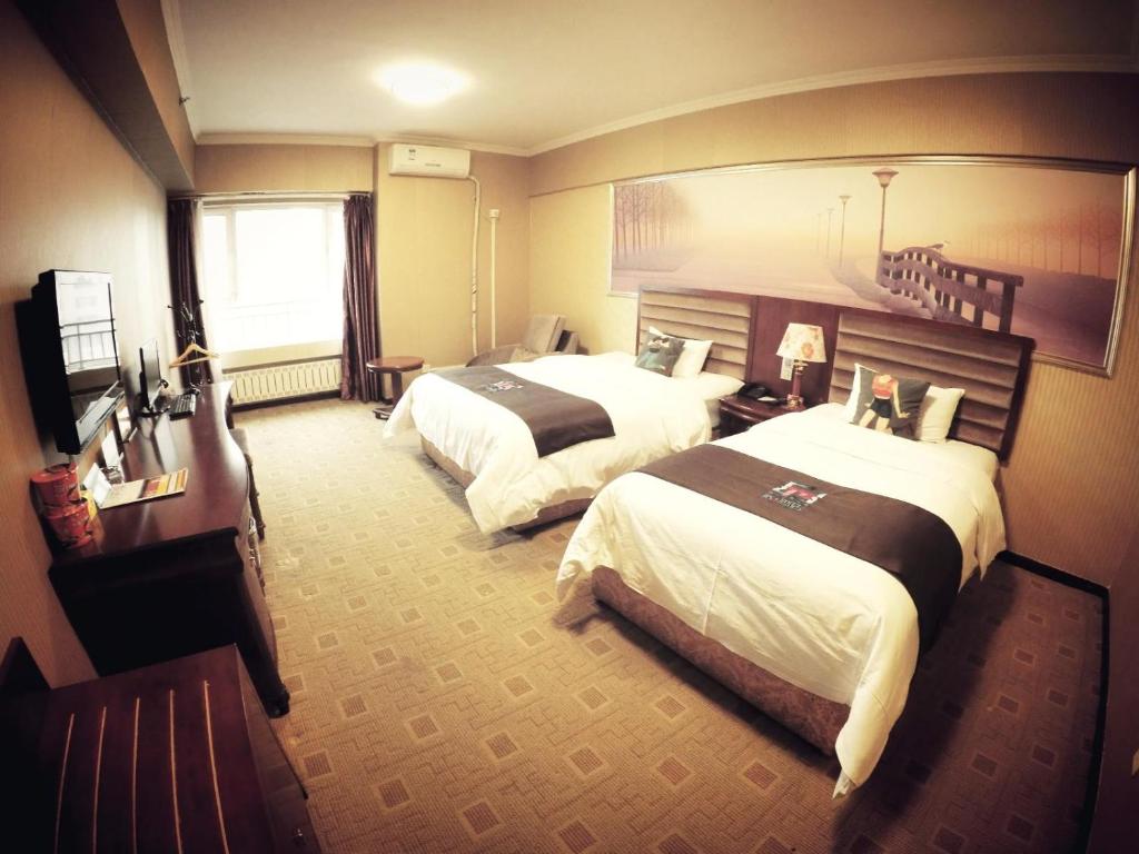 哈尔滨派酒店·哈尔滨索菲亚教堂一面街店的酒店客房设有两张床和窗户。